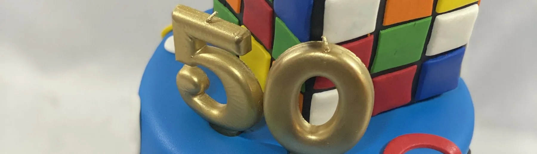 Rubik's Cube birthday cake with gold 50 candles