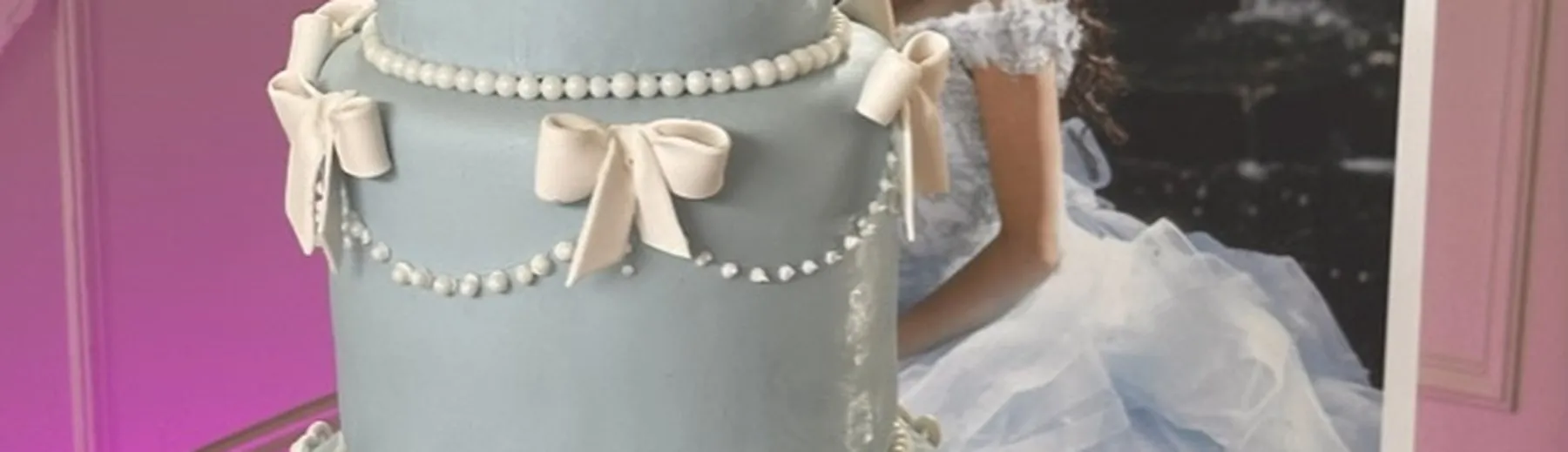 Pale blue wedding cake with sugar bows and pearl swags