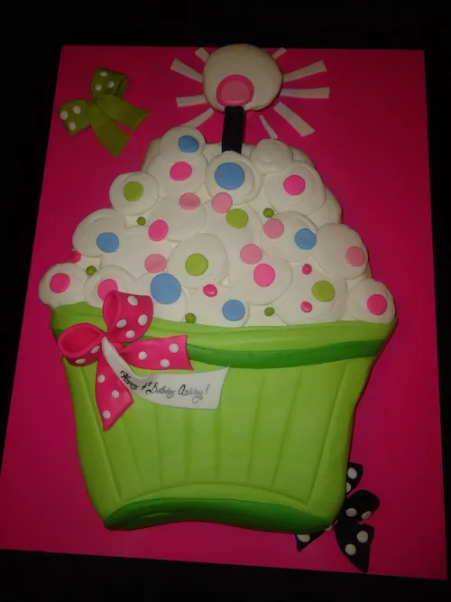 Giant polka dot cupcake-shaped cupcake cake on a hot pink board