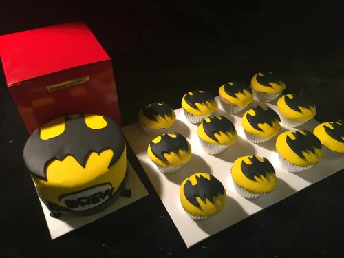 Batman cupcakes with a matching yellow and black bat logo cake