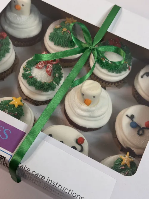 Boxed Christmas cupcakes tied with a green ribbon