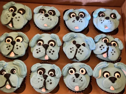 Blue puppy face cupcakes with fondant ears and eyes