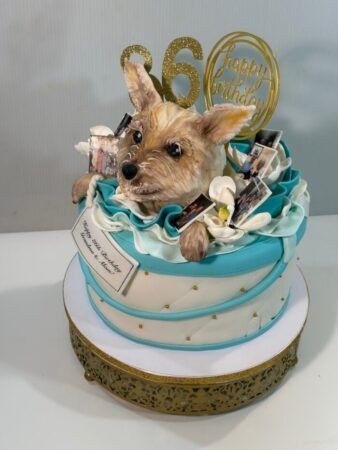 60th birthday cake with a sculpted Yorkie peeking out of teal fondant ruffles