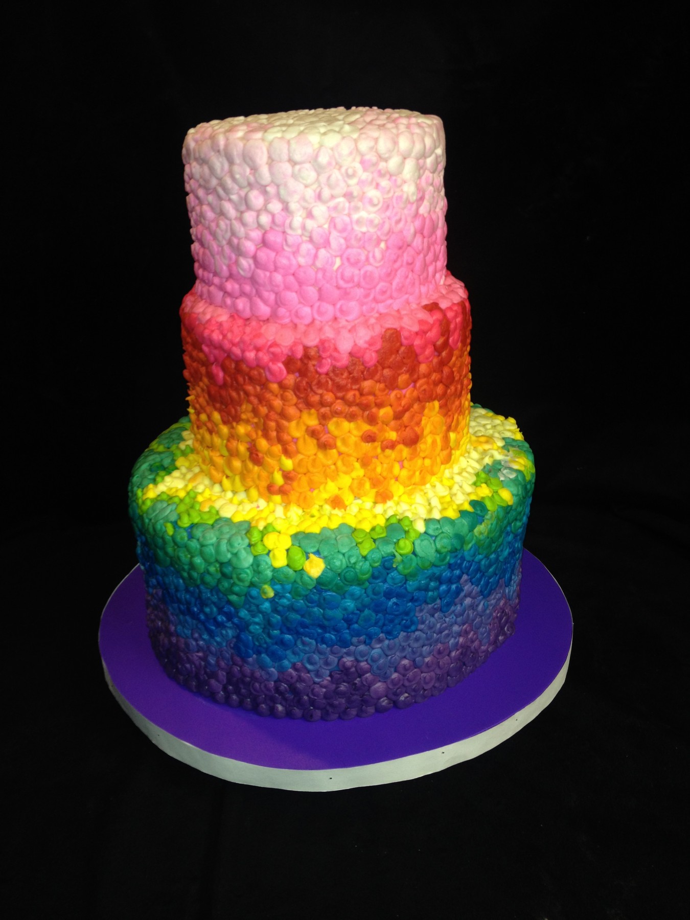 Three-tier rainbow ombre cake with textured petal frosting