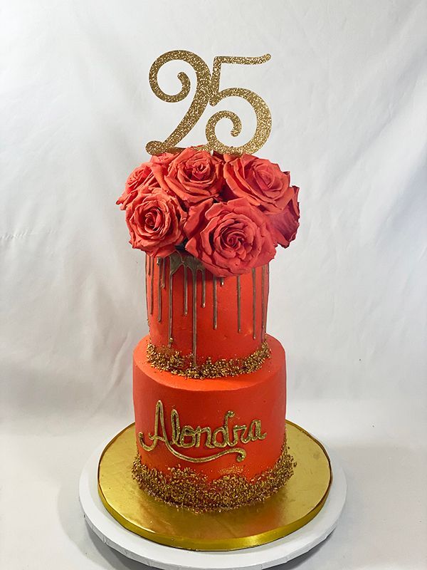 Red two-tier 25th birthday drip cake topped with red roses and gold glitter