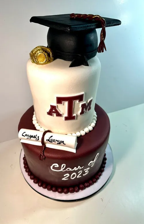 Maroon and white Texas A&M Class of 2023 graduation cake with a cap and Aggie ring