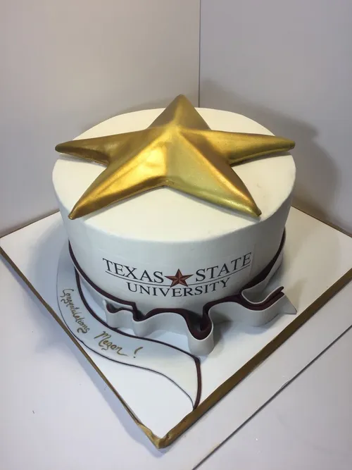 White Texas State University graduation cake topped with a large gold star