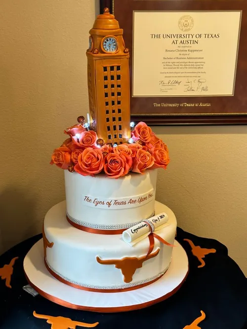 UT Tower graduation cake with orange roses and Longhorn logos beside a UT Austin diploma